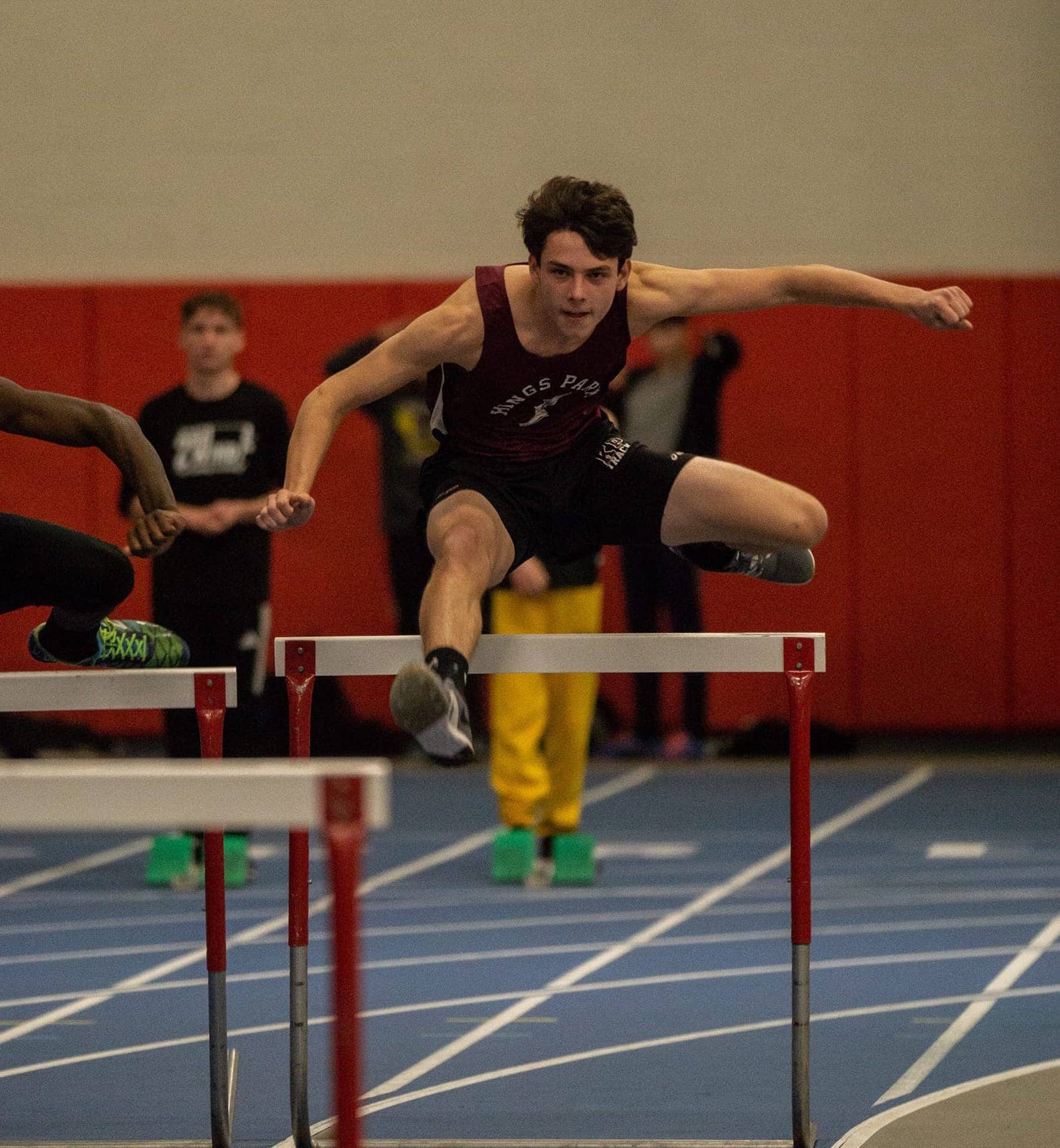 Boy jumping over gate at a track meet